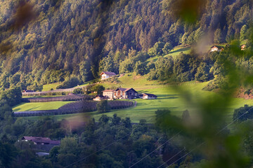 Haus, Gasthaus oder Bauernhaus, Berghütte liegt idyllisch in den Bergen auf einer Wiese mit Wald...
