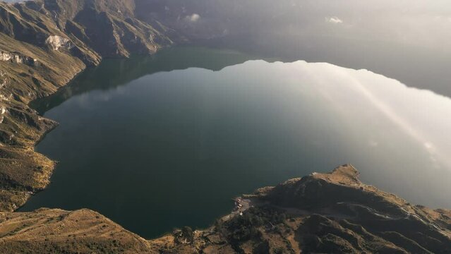 Landscape at Quilotoa, Volcanic Crater Lake In Ecuador, Aerial Drone Above Water Calming Scenic View along Morning Sun Rays