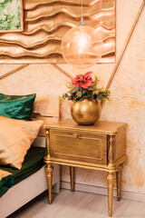 Bedside table of gold color in the bedroom. Home interior