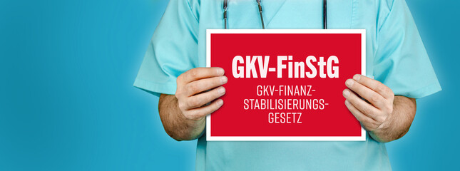 GKV-FinStG (GKV-Finanzstabilisierungsgesetz). Arzt zeigt rotes Schild mit medizinischen Wort...