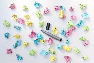 Empty note papers with a black marker and crumbled paper on white isolated background