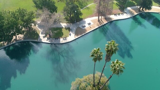 Aerial Tilt Down Beautiful View Of Rsm Lake In Park By Houses On Sunny Day - Los Angeles, California