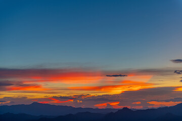 Fototapeta premium The dramatic colors of the sunset in the sky gradient from blue to orange.