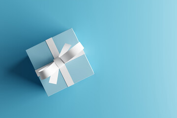 Blue gift box with white ribbon on blue background with copy space.