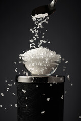 Sea salt is poured into a small bowl.