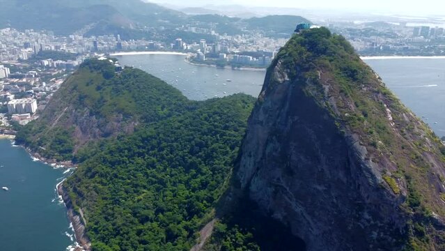 Panning Left Sugarloaf Mountain Cliffside view panning to tropical Red Beach Brazil (Praia vermelha), Blue Waters And Mega Yachts 
Rio de Janeiro, Brazil by Drone 4k
Aerial Nature + Travel