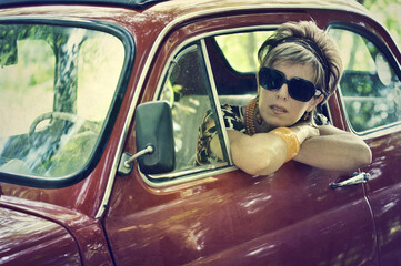 Woman in 70's clothing in vintage car