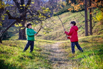 Two brothers fight with sticks. The child screams with his mouth