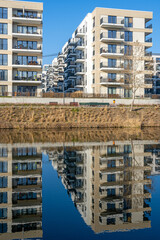 New apartment buildings with a perfect reflection in a small canal seen in Berlin, Germany