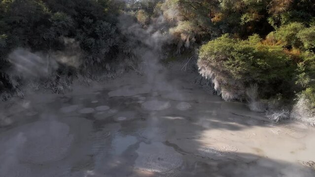 Slow aerial ascent above a boiling mud pool in Waiotapu, Rotorua, New Zealand