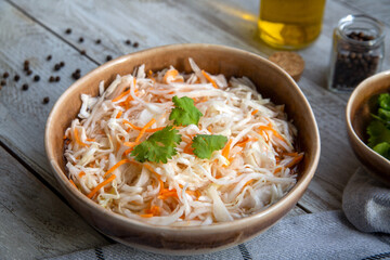 Sauerkraut in a ceramic bowl on a wooden table. Fermented food. Vegetarianism, healthy food.