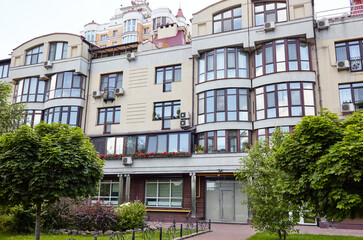 Naklejka premium Modern apartment buildings on a sunny day with a blue sky. Facade of a modern European apartment building, Kyiv, Ukraine. Abstract architecture, fragment of modern urban geometry