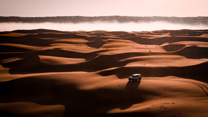 Car crossing fog in the desert