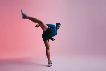 Rolgordijnen Man throwing a martial arts kick in virtual reality © Jacob Lund