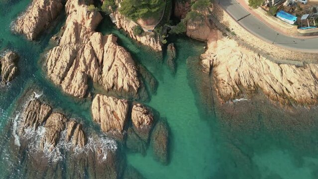 Aerial view of rocks in the transparent turquoise blue Mediterranean Sea Sant Pol beach in S'Agar&oacute;