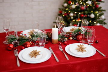 Served table for christmas dinner with plates, forks, knifes and glasses