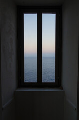 Il panorama del mare del Salento visto da una finestra del faro di Punta Palascia vicino a Otranto in Puglia, il punto più a est d'Italia