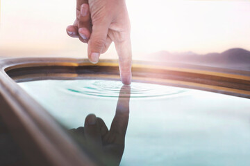 person touching a source of water reflected in a mirror, concept of source of life