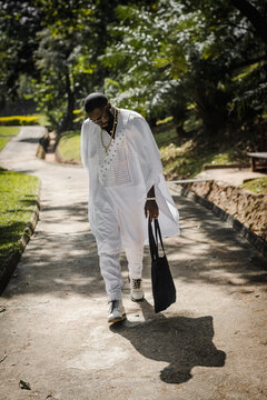 an african man in an agbada taking a walk in the park