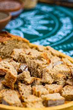 Close-up of a brown sourdough loaf and cubes of bread on a traditional Georgian tablecloth
