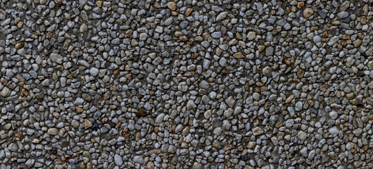 Panorama of small pebbles in concrete wall for background