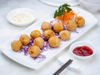Deep fried crab balls with cheese served on white porcelain plate
