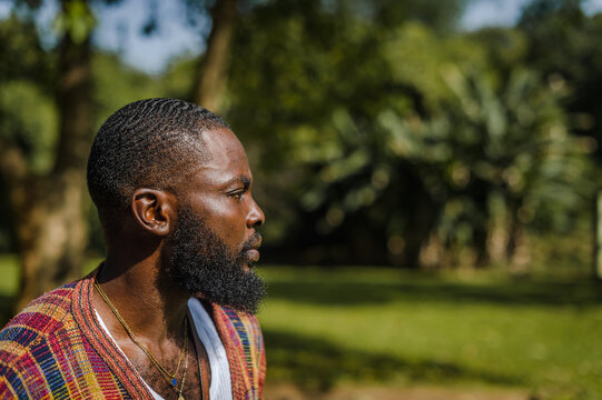 A closeup of black man in a garden posing for a portrait