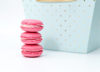Three pink macaroons on the background of a blue box