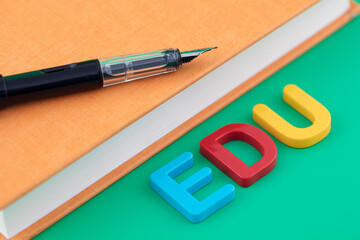 EDU and a pen on a book