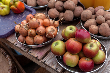 Apples, onions, potatoes, peppers. A vegetable counter at a street market. Trade in seasonal goods.