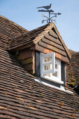 A dormer on top of a roof covered with clay flat tiles