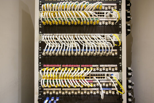 Many multicolored cables of the UTP LAN cable with sticker label connected line arrangement to Ethernet Switch that are installed in the rack cabinet. close up.