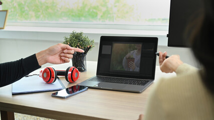 Cropped shot of creative retouchers team editing digital photos, collaborating on new project together at office