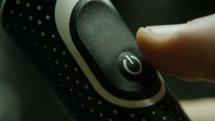 Power button close-up, a finger pressing to power button, energy and technology concept