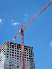 Fototapeta premium Minimalism. Building under construction and construction crane. Aesthetic view of the construction site