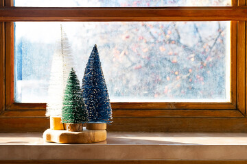 Colourful Christmas trees on the window. Trendy home decor for winter holidays.