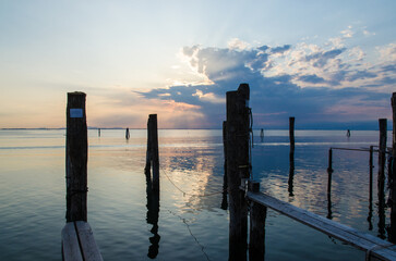 Il crepuscolo con le nuvole che si riflettono nelle acque calme della laguna di Venezia visto dall'isola di Pellestrina