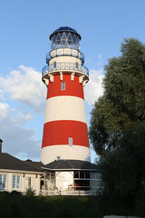 Lighthouse. Fishing Village hotel in Ryazan region, Russia. Russian nature, landscape. Red lighthouse in Norwegian, Scandinavian style. Ryazan landmark. Summer scenery. Beautiful lighthouse, beacon