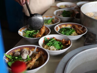 Selective focus Mie ayam, mi ayam or bakmi ayam indonesian for chicken bakmi, literally chicken noodles, is a common Indonesian dish of seasoned yellow wheat noodles topped with diced chicken meat.