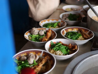Selective focus Mie ayam, mi ayam or bakmi ayam indonesian for chicken bakmi, literally chicken noodles, is a common Indonesian dish of seasoned yellow wheat noodles topped with diced chicken meat.