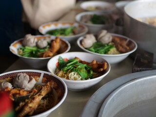 Selective focus Mie ayam, mi ayam or bakmi ayam indonesian for chicken bakmi, literally chicken noodles, is a common Indonesian dish of seasoned yellow wheat noodles topped with diced chicken meat.