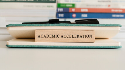 Academic Acceleration writing on wooden surface. Book and wood concept. Education and work.