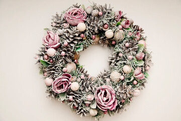 Festive background with an Advent wreath. Christmas mood. Handmade decoration with flowers and frost. Natural pink - purple color.