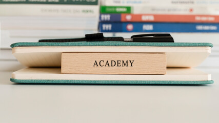 Academy writing on wooden surface. Book and wood concept. Education and work.