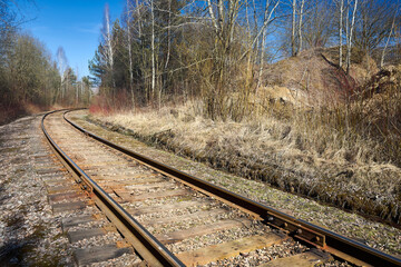 Fototapeta premium Railway track in the spring forest with blue sky with railway drainage system rail construction. Rail trackside drainage. Drainage channels of railway.