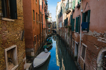 Fototapeta na wymiar Uno scorcio di un piccolo canale di Venezia con delle barche ormeggiate