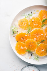 Traditional sicilian italian  vitamin salad with fennel and orange. Fennel and orange citrus salad on the white plate. Raw, vegan cuisine. Winter salad, close up
