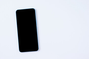 Smartphone with a black display on white background. Place for text. View from above.
