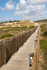 Fototapeta na wymiar Guincho wooden pathway through the sand dunes