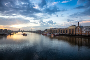 Fototapeta na wymiar View of River Thames and City Skyline during dramatic sunrise. City of London, United Kingdom. Travel Destination